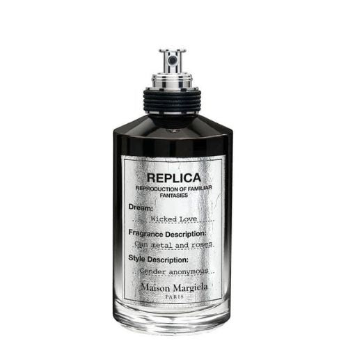 Maison Margiela Replica Wicked Love 100 ml Eau de Parfum, transparent bottle with black label and metallic cap, set against a soft-focus floral backdrop.